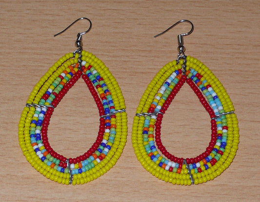 Boucles d'oreilles aux couleurs exotiques en forme de gouttes composées de perles de rocaille principalement jaunes, puis rouges et d'un mélange de perles multicolores enfilées sur cinq rangées de fils de fer. Elles mesurent 7,5 cm de long et 4 cm de large et se portent avec des crochets en acier inoxydable sur des oreilles percées.