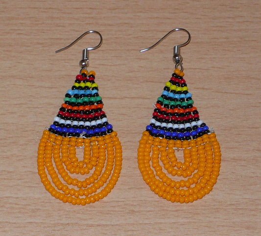 Boucles d'oreilles africaines traditionnelles zouloues en forme de gouttes composées d'un tissage de perles de rocaille orange et multicolores. Elles mesurent 7 cm de long et 2,5 cm de large et se portent sur des oreilles percées. Timeless Fineries