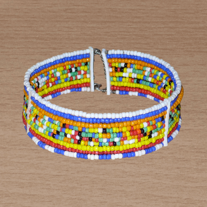 Bracelet africain Massai composé de dix rangées de perles multicolores enfilées sur des fils de fer fixés sur des charnières en plastique. Le bracelet se ferme avec deux crochets.