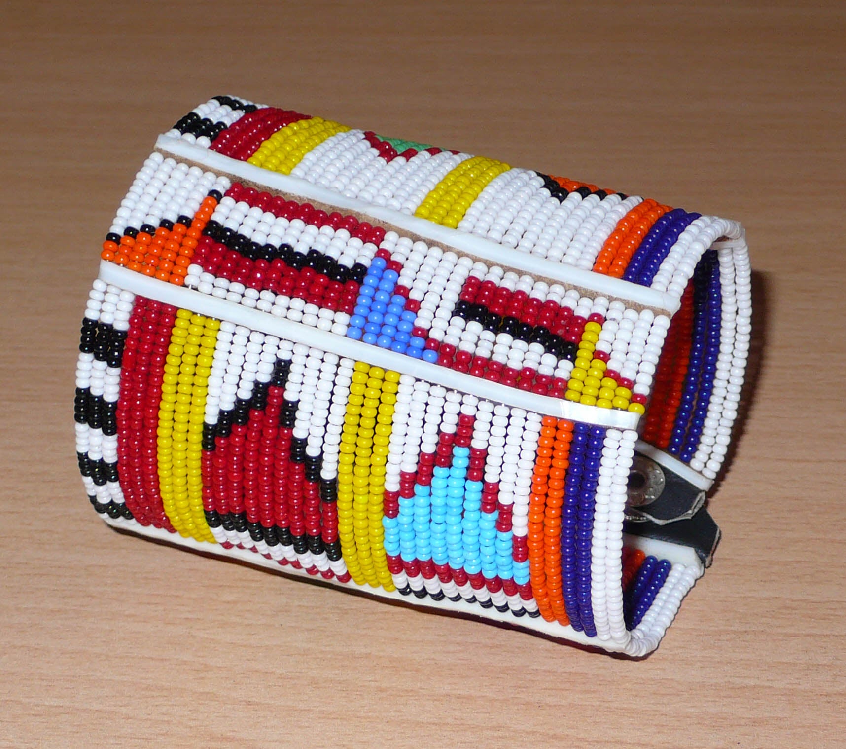 Bracelet africain multi-rangs à motifs ethniques traditionnels Massai composé de trente-six rangées de perles de rocaille blanches et multicolores.