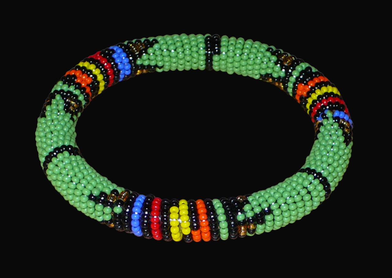 Bracelet africain tubulaire à motifs tribaux zoulous fait de perles de rocaille vertes et multicolores glissées sur du fils de nylon enroulé autour d'un tube en plastique.
Ce bracelet a une circonférence de 21 cm, un diamètre de 6.5 cm et une épaisseur de 1 cm.
Il peut être porté par une femme ou par un homme.