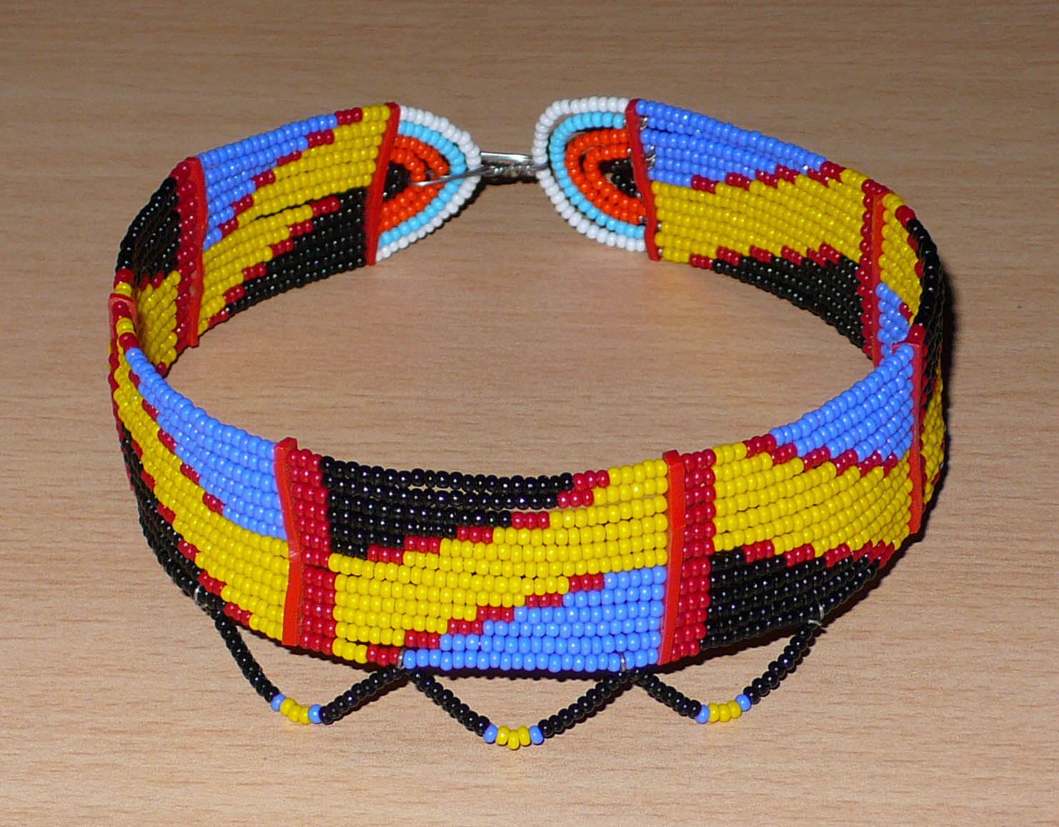 Collier africain Massai multi-rangs à motifs ethniques composé de douze rangées de perles principalement jaunes, bleues, noires et rouges.