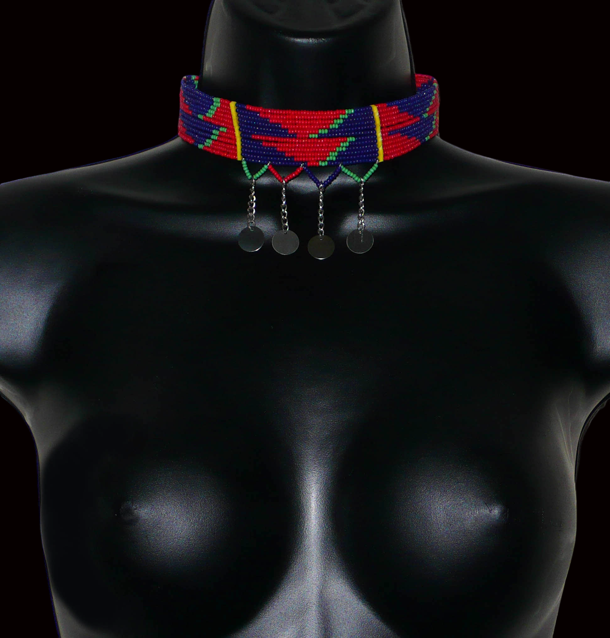 Collier ras de cou africain de tradition Massai composé de douze rangées de perles de rocaille rouges, bleu marine et vertes enfilées sur des fils de fer insérés dans des charnières en plastique jaune. Le collier est décoré chaînettes prolongées de petits disques métalliques ; il se ferme avec un crochet.