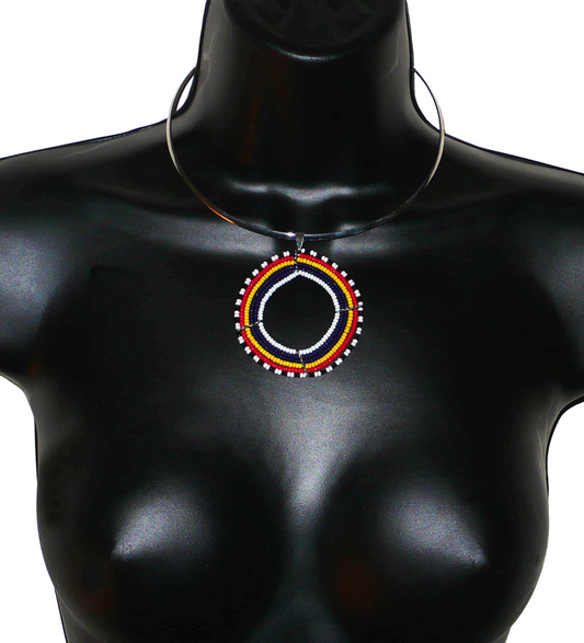 Collier africain au style contemporain composé d'un ras de cou en laiton argenté agrémenté d'un large médaillon Massai en perles de rocaille bleu foncé, rouges, jaunes, blanches et noires montées sur une structure circulaire en fils de fer.