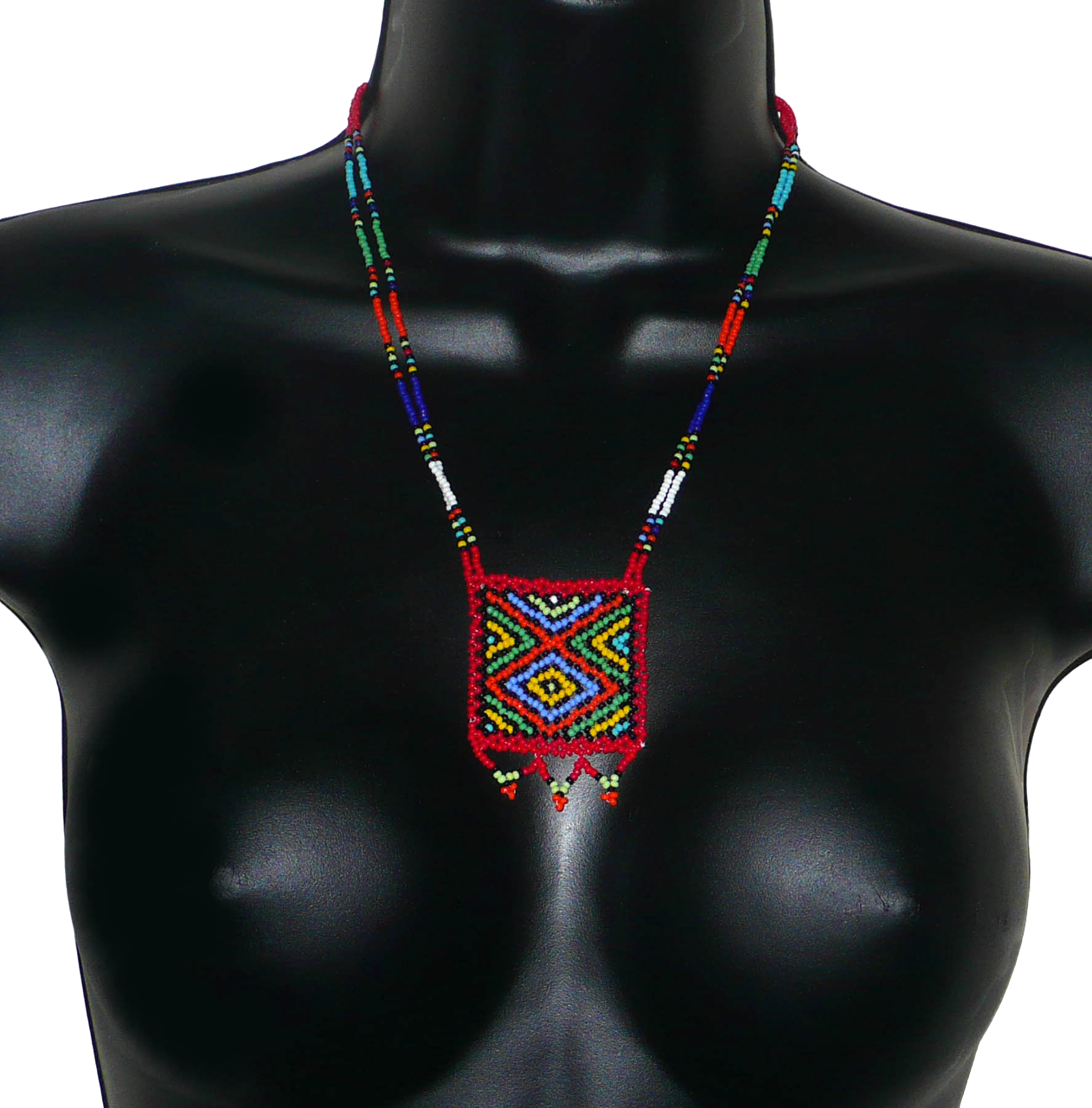 Collier africain en perles de rocaille rouges et multicolores agrémenté d'un pendentif carré à motifs ethniques. Il mesure 27,5 cm de long (en partant de la nuque jusqu'à la base du pendentif), le pendentif mesure 5,5 cm sur 4,5 cm ; le collier s'attache avec un fermoir à boule. Timeless Fineries