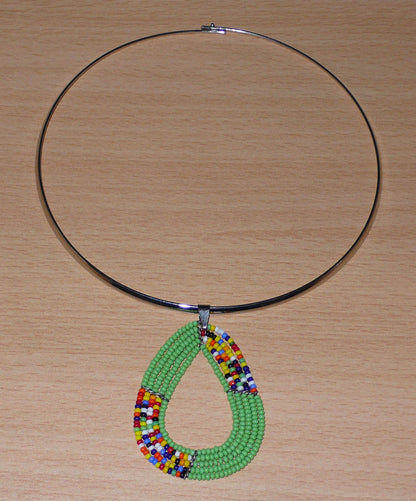 Collier ethnique vert et multicolore composé d'un ras de cou en laiton agrémenté d'un pendentif kenyan triangulaire aux bords arrondis fait de  perles de rocaille.