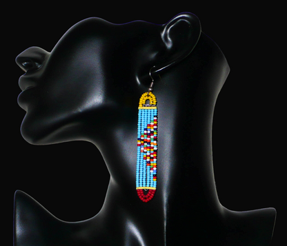 Longues boucles d'oreilles africaines à la mode kenyane composées de perles de rocaille bleu ciel, rouges, jaunes et multicolores montées sur six rangées de fils de fer en forme de rectangles aux extrémités arrondies. 

Ces boucles d'oreilles aux accents exotiques mesurent 9 cm de long et 1.5 cm de large ; elles se portent avec des crochets en acier inoxydable sur des oreilles percées.