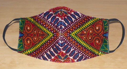 Masque textile ajusté, coupé et cousu dans un tissu africain en coton imprimé de motifs tribaux multicolores ; il se porte avec des élastiques. En vue d'une utilisation éco-responsable, ce masque est lavable et réutilisable.  Ce masque à l'allure ethnique chic mesure 21 cm de long, et 40 cm en comptant les élastiques ; il a une hauteur de 12 cm (du haut du nez jusqu'au menton) et une largeur sur les côtés de 7 cm.