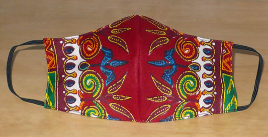 Masque facial en tissu africain bordeaux imprimé de motifs exotiques multicolores ; il se porte avec des élastiques. En vue d'un usage éco-responsable, il est lavable et réutilisable.  Ce masque textile mesure 21 cm de long, et 40 cm en comptant les élastiques ; il a une hauteur de 12 cm (du haut du nez jusqu'au menton) et une largeur sur les côtés de 7 cm.