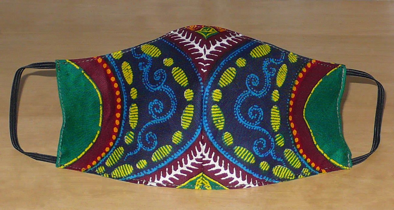 Masque textile pour homme à la coupe ajustée, cousu dans un beau tissu africain en coton à motifs tribaux ; il se porte avec des élastiques. En vue d'une utilisation  éco-responsable, ce masque est lavable et réutilisable.  Ce masque au style afro-caribéen mesure 21 cm de long, et 40 cm en comptant les élastiques ; il a une hauteur de 12 cm (du haut du nez jusqu'au menton) et une largeur sur les côtés de 7 cm.  Pour des raisons évidentes d'hygiène, les retours et les échanges de masques ne sont pas acceptés