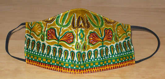 Masque en tissu africain à la coupe ajustée, coupé et cousu dans une cotonnade couleur jaune moutarde imprimée de motifs ethniques multicolores ; il s'attache avec des élastiques. En vue d'une utilisation eco-friendly, ce masque est lavable et réutilisable.  D'allure exotique, ce masque mesure 21 cm de long, et 40 cm en comptant les élastiques ; il a une hauteur de 12 cm (du haut du nez jusqu'au menton) et une largeur sur les côtés de 7 cm.  Pour des raisons évidentes d'hygiène, les retours et les échanges 