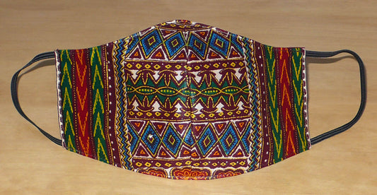 Masque textile ajusté, coupé et cousu dans un tissu africain en coton imprimé de motifs tribaux multicolores ; il se porte avec des élastiques. Fabriqué dans une approche éco-responsable, ce masque est lavable et réutilisable.