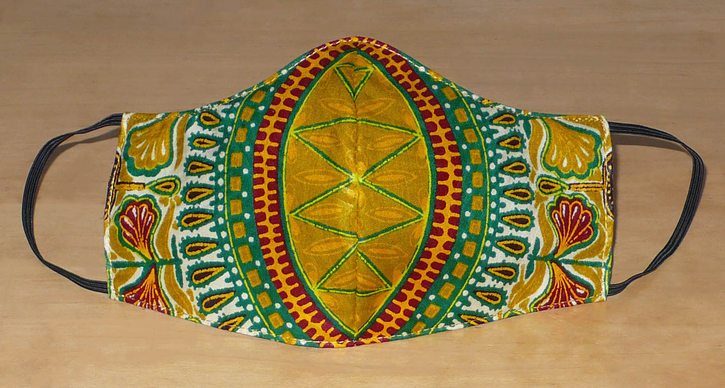 Masque facial en tissu africain jaune d'or imprimé de motifs exotiques multicolores ; il se porte avec des élastiques. En vue d'un usage éco-responsable, il est lavable et réutilisable.