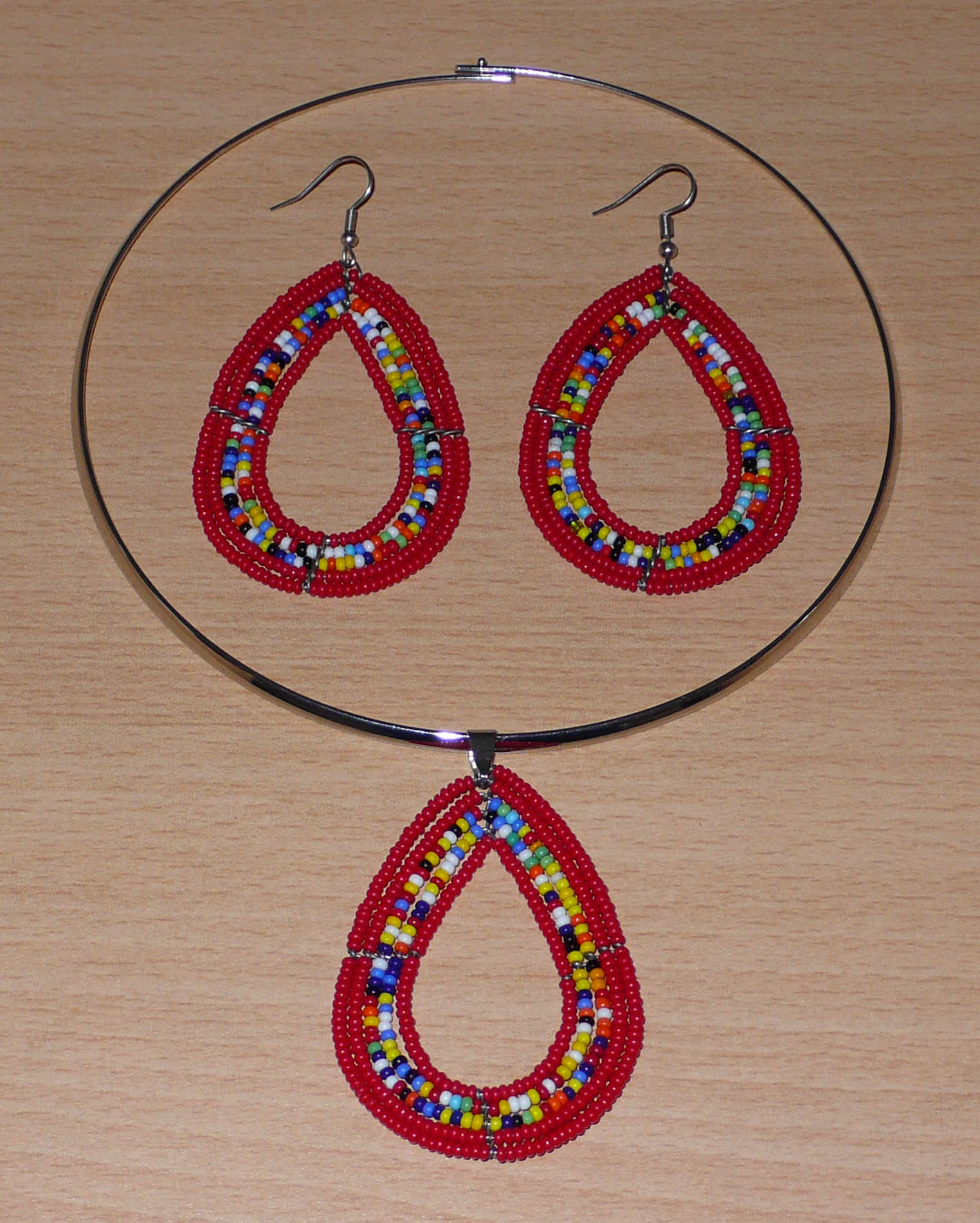 Parure contemporaine de bijoux Massai au style ethnique chic composée d'un collier ras-de-cou orné d'un pendentif en perles de verre rouges et multicolores en forme de goutte, et d'une paire de boucles d'oreilles assorties.