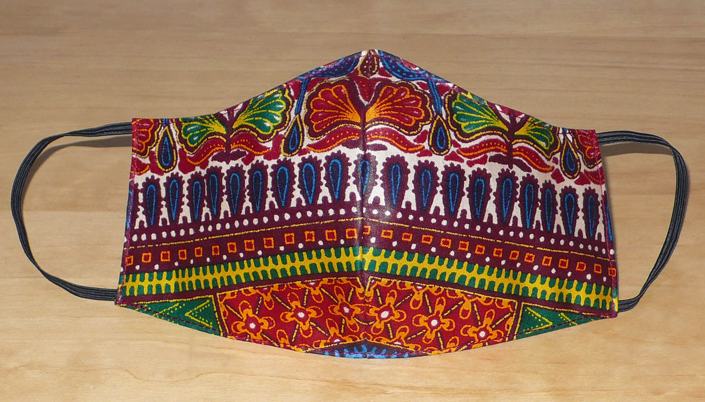 Masque textile coupé et cousu dans un tissu en coton imprimé de motifs africains. Lavable et réutilisable, il se porte avec des élastiques.