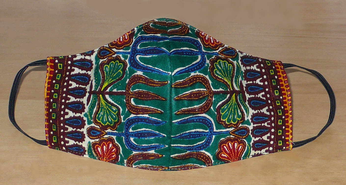 Masque facial coupé et cousu dans un tissu en coton à motifs africain. Lavable et réutilisable ; il se porte avec des élastiques.